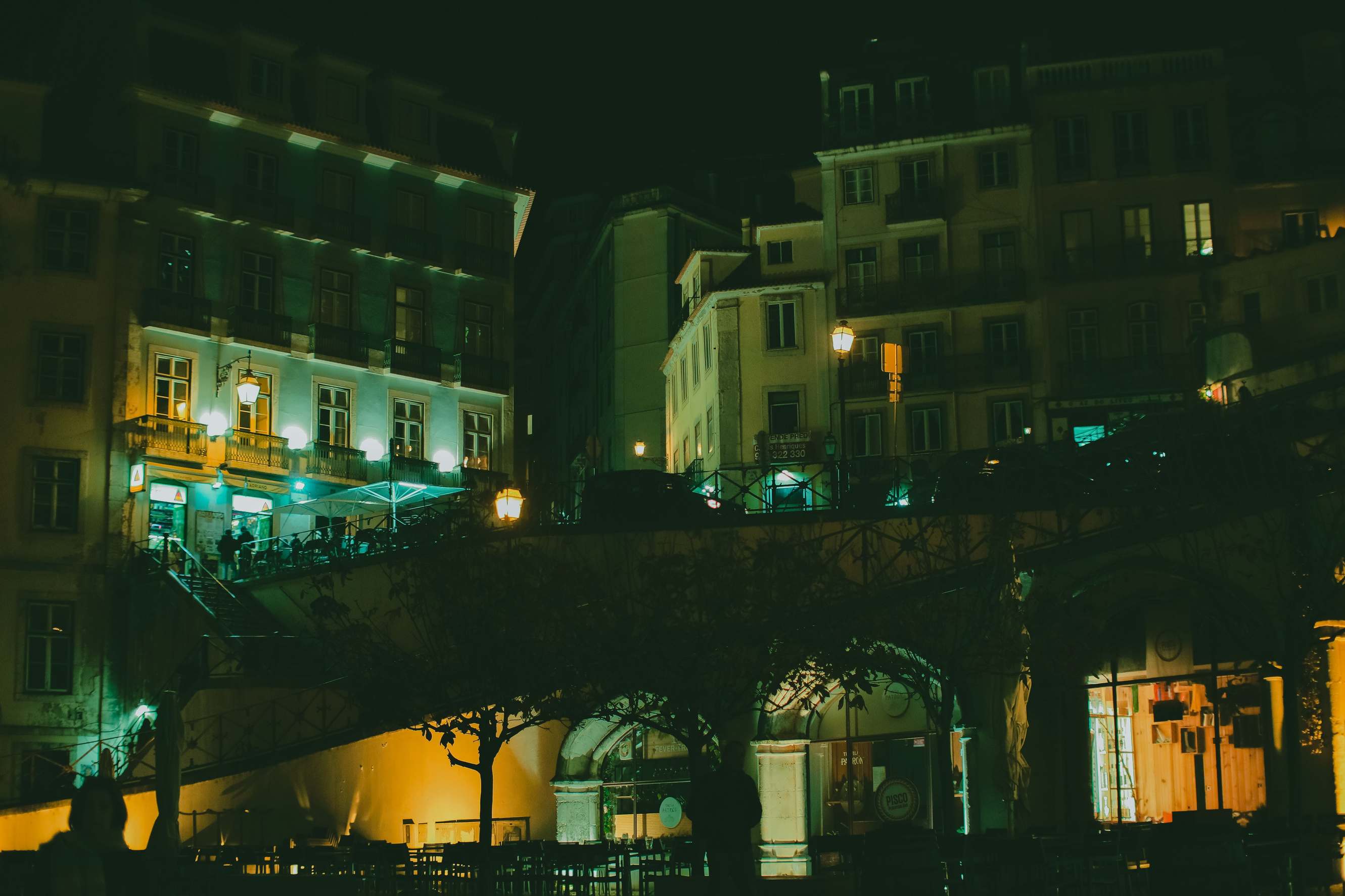 Office building exterior at night with city lights, illuminated urban architecture